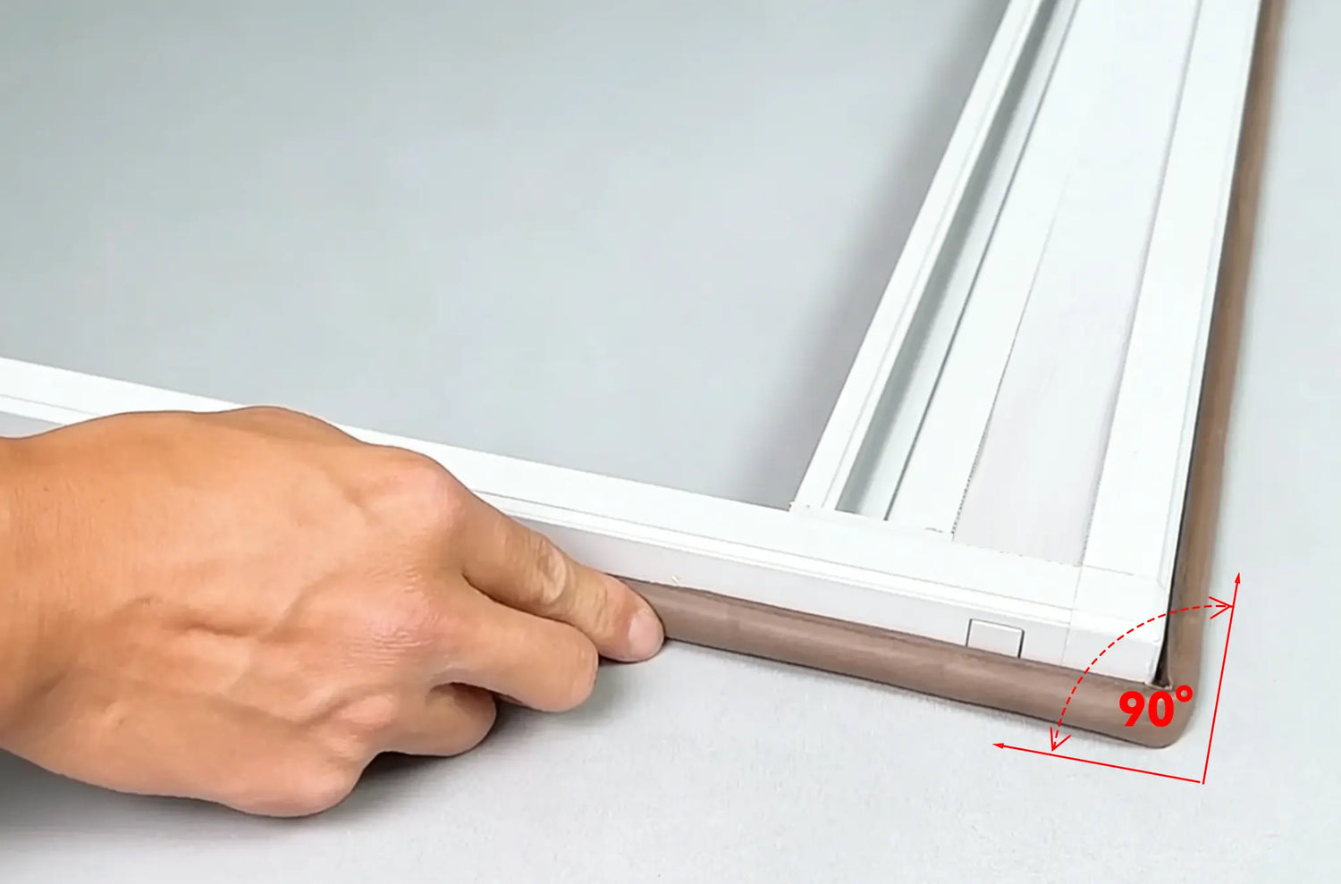 Applying sealing strips to the frame edges, ensuring a relaxed fit at the corners to prevent light leaks.