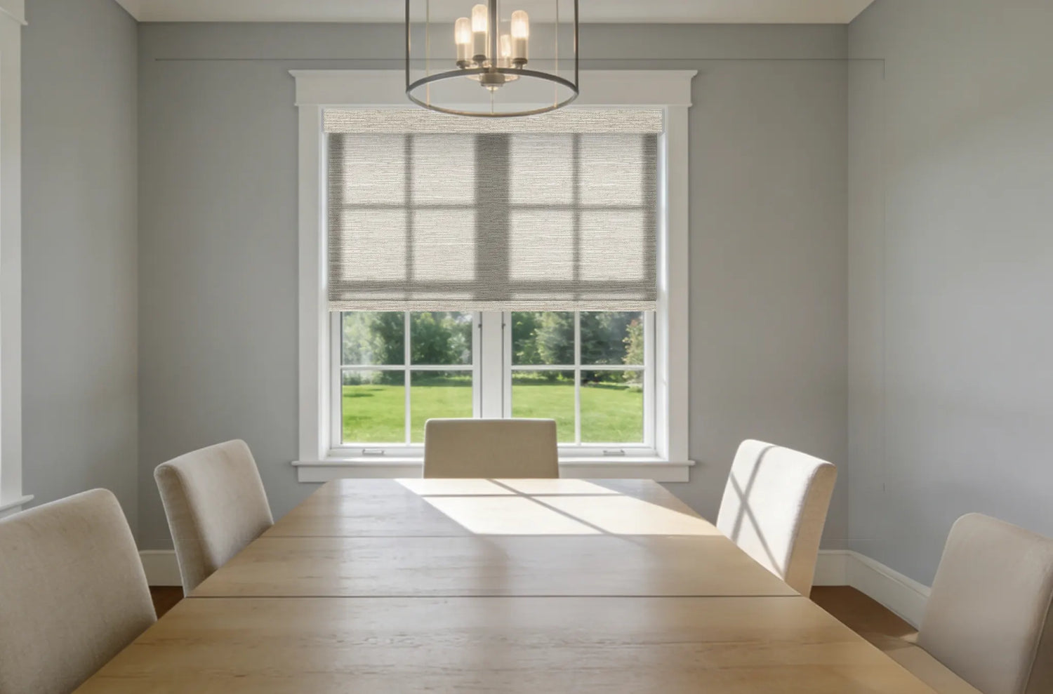 Dining room with ivory linen texture roller shades filtering soft sunlight.