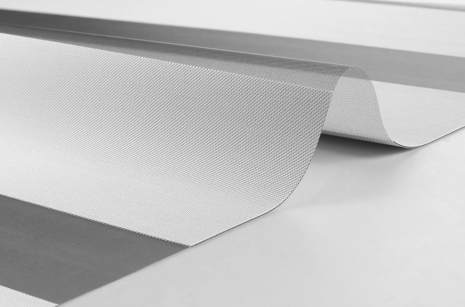 Close-up texture of Kurlax EliteGuard 100% blackout polyester fabric for zebra shades.