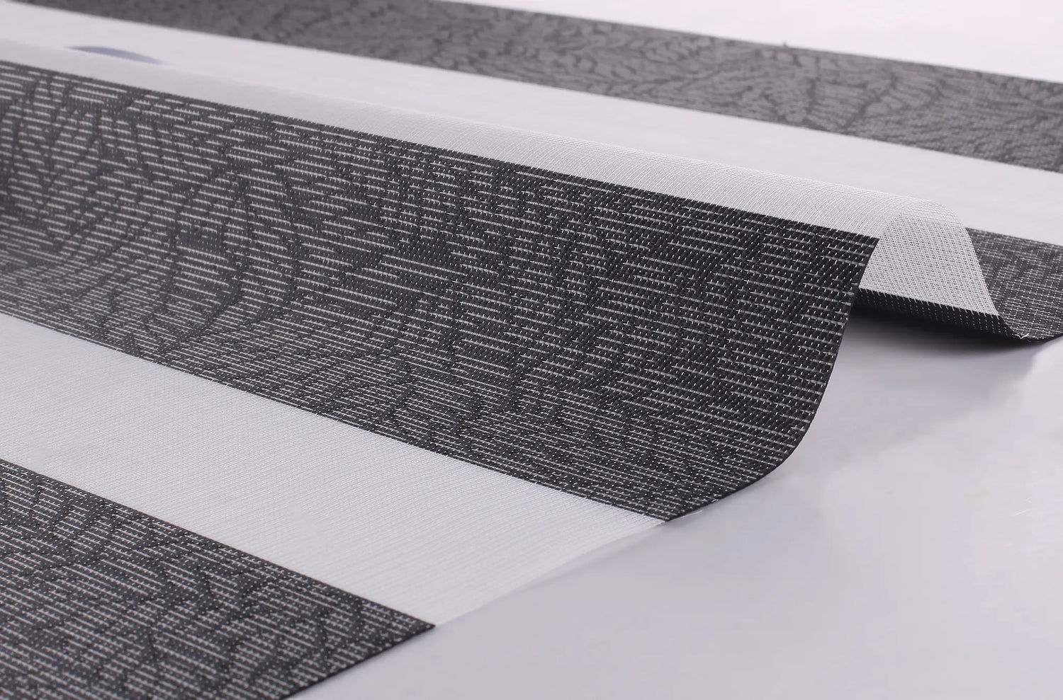 Close-up of the Foliage Weave series 100% polyester room darkening fabric showing the high-quality texture and foliage pattern.