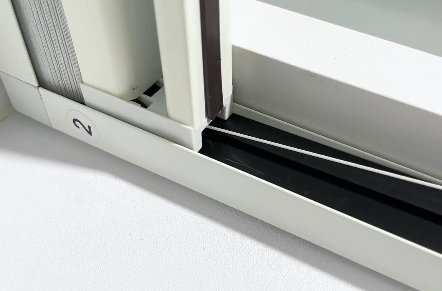 Tucking the fabric and pull cords into the side rail rubber strips.