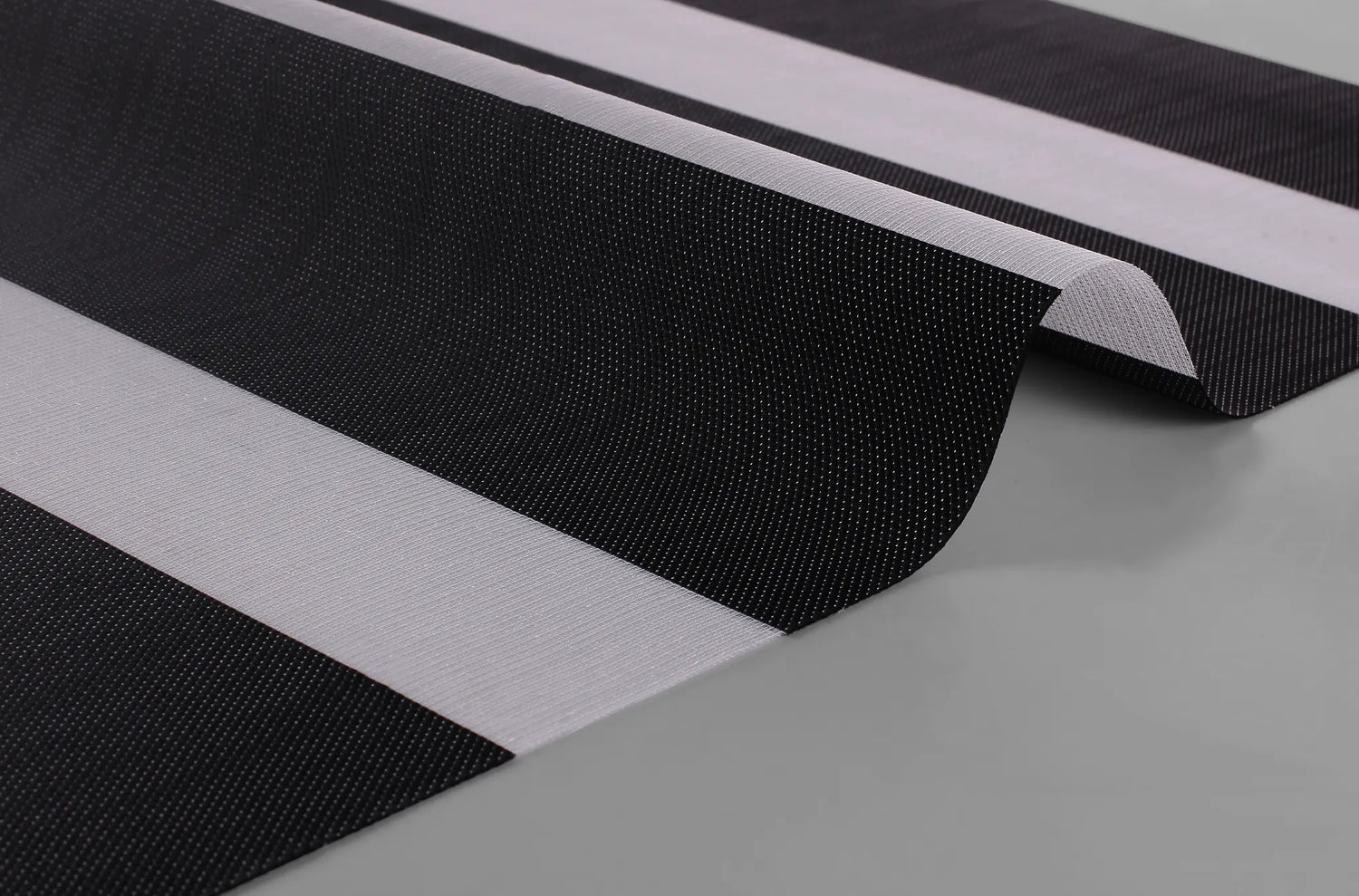 Close-up of Kurlax Enigma Weave fabric showing the irregular dark-veined pattern and 70% blackout quality.