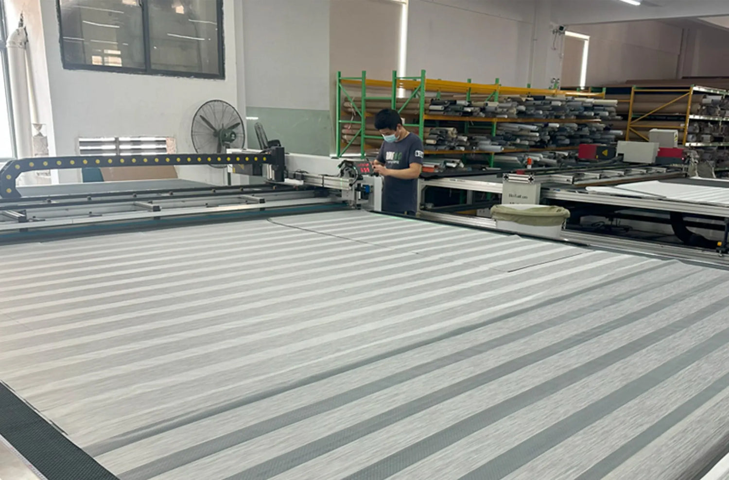 Laser cutting fabric for Kurlax custom motorized window shades, showcasing precision and craftsmanship