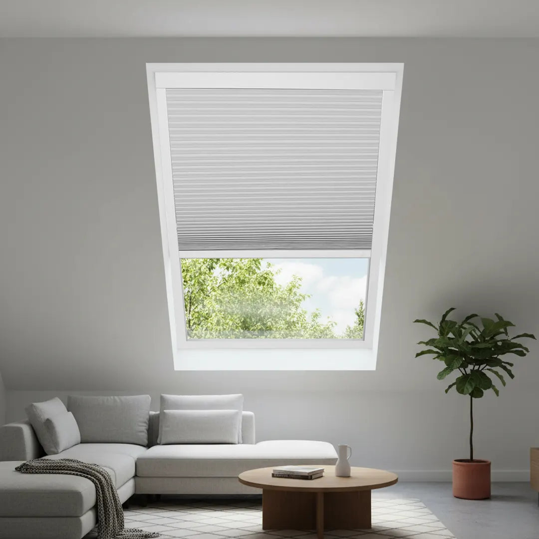 Motorized skylight shade installed on a pitched skylight for hands-free remote and voice control.