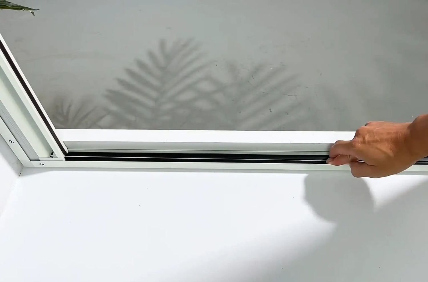 Pressing the rubber strips firmly into the side rail grooves.